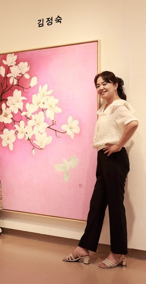 창원 성산아트홀 부스에서 자신의 목련 작품 옆에 선 김정숙 작가
