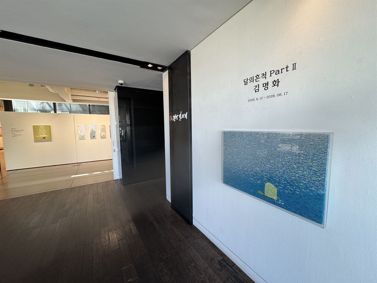 전시장을 나서며 — 복도에서 본 제목 벽면