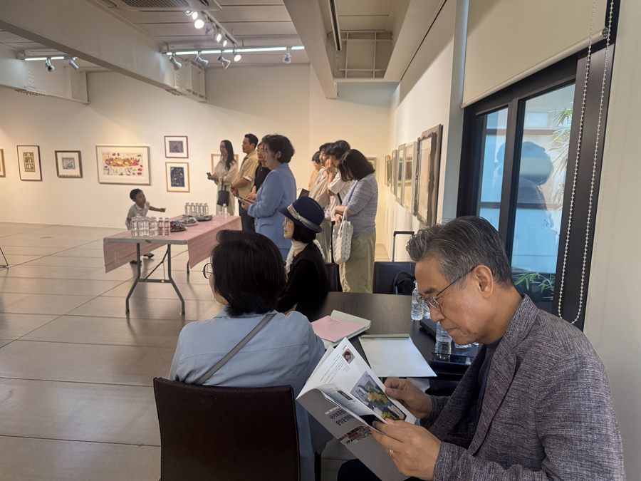 오픈식 — 도록을 펼쳐 보는 참석자