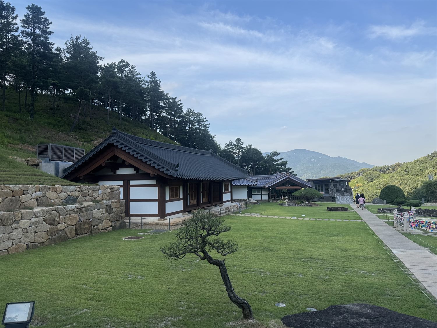 한옥 전각과 소나무, 잔디마당 너머로 지리산 능선이 펼쳐진 수선사 전경