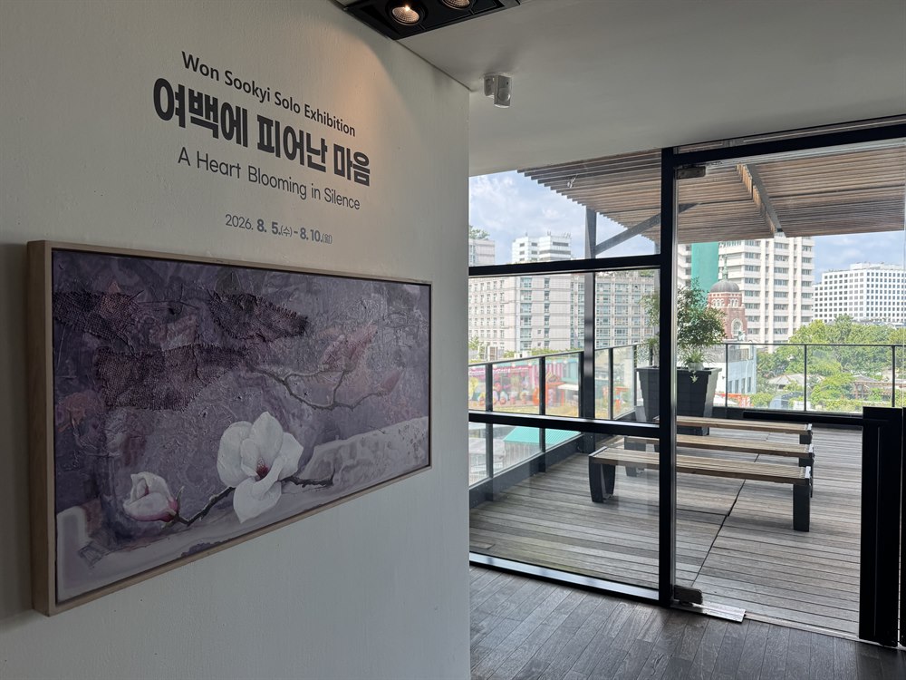 전시 제목 벽면 너머로 인사동 풍경이 내다보이는 경남갤러리 옥상 테라스